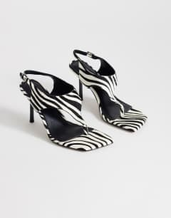 Model wearing Sandy hair on real leather toe thong heeled sandal in black and white zebra