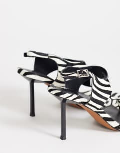 Model wearing Sandy hair on real leather toe thong heeled sandal in black and white zebra