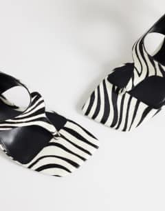 Model wearing Sandy hair on real leather toe thong heeled sandal in black and white zebra