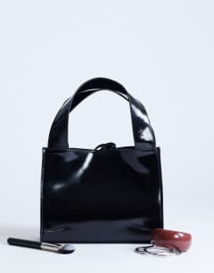 Model wearing Sandy small real suede and leather grab bag with tie fastening in black