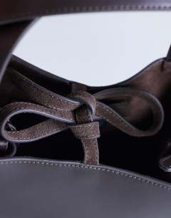 Model wearing Sandy small real suede and leather grab bag with tie fastening in chocolate