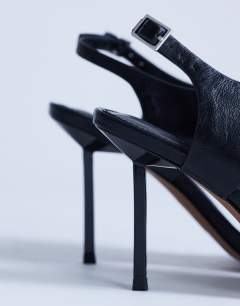 Model wearing Sandy toe thong heeled sandal in black 