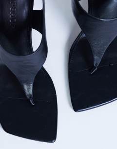 Model wearing Sandy toe thong heeled sandal in black 