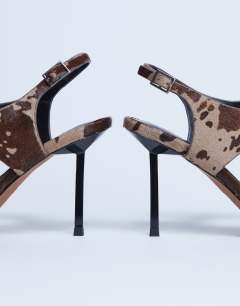 Model wearing Sandy toe thong heeled sandal in brown cow print hair on real leather 