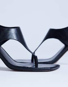 Model wearing Sandy toe thong high heeled sandal in black