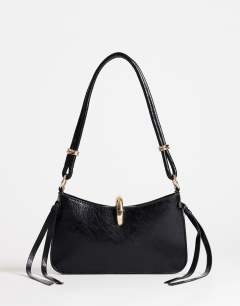 Model wearing Sansa small shoulder bag with hardware in black