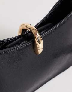 Model wearing Sansa small shoulder bag with hardware in black