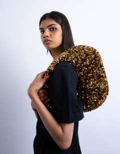 Model wearing Santana scoop sequin shoulder bag in gold