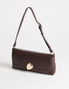 Model wearing Santiago small shoulder bag with gold hardware in chocolate