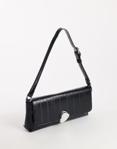 Model wearing Santiago small suedette shoulder bag with silver hardware in black