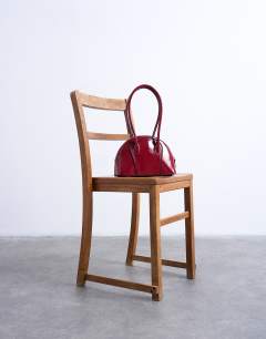 Model wearing Saoirse patent shoulder bag in burgundy