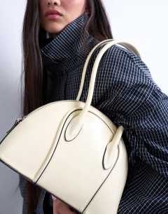 Model wearing Saoirse patent shoulder bag in buttermilk