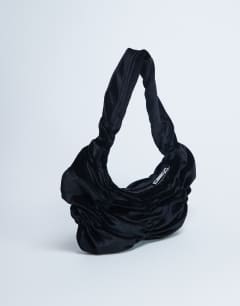 Model wearing Saphire ruched velvet shoulder bag in black