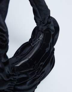 Model wearing Saphire ruched velvet shoulder bag in black