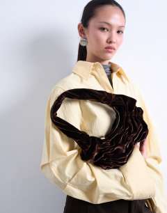 Model wearing Saphire ruched velvet shoulder bag in chocolate