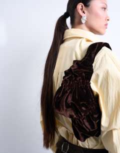Model wearing Saphire ruched velvet shoulder bag in chocolate