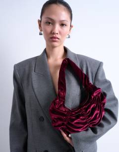 Model wearing Saphire ruched velvet shoulder bag in plum