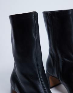 Model wearing Sara Premium leather square toe flared heel boot in black