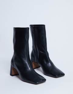 Model wearing Sara Premium leather square toe flared heel boot in black