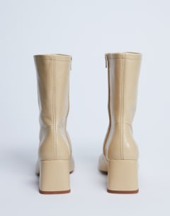 Model wearing Sara Premium leather square toe flared heel boot in buttermilk