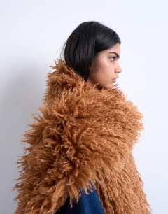 Model wearing Sara shaggy faux fur blanket scarf in tan