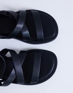 Model wearing Sasha strappy flat sandal in black