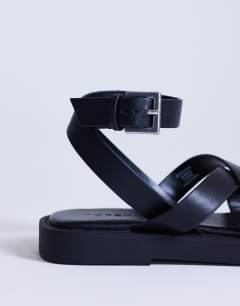 Model wearing Sasha strappy flat sandal in black