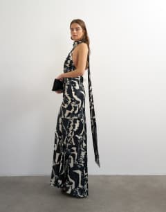 Model wearing Satin asymmetric halter neck maxi dress with fringed scarf in animal print