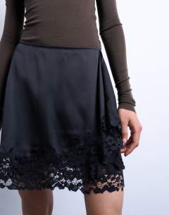 Model wearing Satin asymmetric mini skirt with lace trim in black