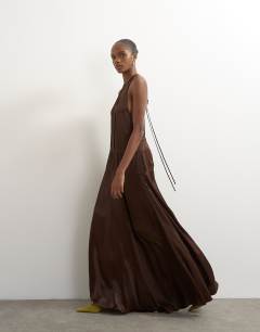 Model wearing Satin dropped waist low armhole maxi dress in chocolate
