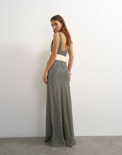 Model wearing Satin dropped waist maxi dress with contrast tie belt in mono geometric print
