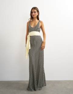 Model wearing Satin dropped waist maxi dress with contrast tie belt in mono geometric print