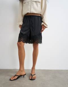 Model wearing Satin feel lace insert bermuda short in black