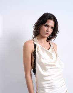 Model wearing Satin halter cowl neck mini dress with black contrast lace trim in oyster