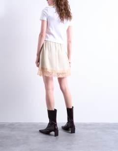 Model wearing Satin lace petticoat mini skirt with contrast lace in oyster