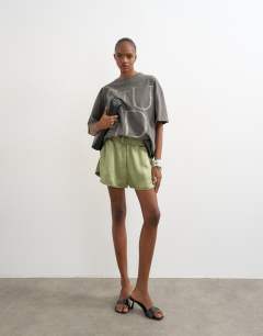 Model wearing Satin runner short with deep waistband in green