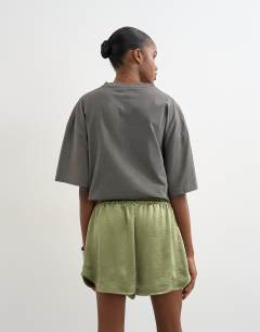 Model wearing Satin runner short with deep waistband in green