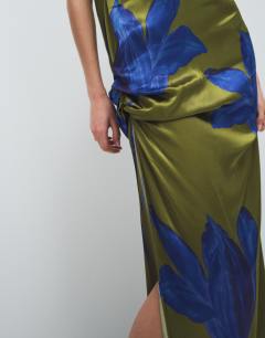 Model wearing Satin sleeveless asymmetric drape maxi dress in green and blue floral