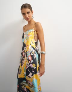 Model wearing Satin strappy square neck maxi dress with fringed hem in black based floral print