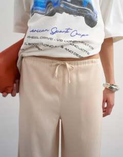 Model wearing Satin tie waist wide leg trouser in ecru