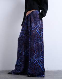 Model wearing Satin wide leg trouser in blue and burgundy print