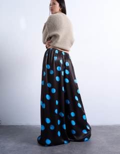 Model wearing Satin wide leg trousers in blue and brown polka dot