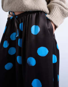 Model wearing Satin wide leg trousers in blue and brown polka dot
