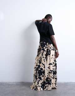 Model wearing Satin wide leg trousers in cow print
