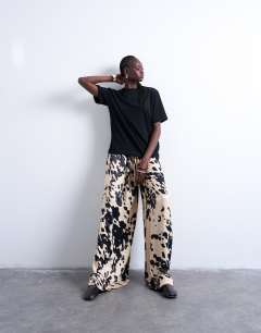 Model wearing Satin wide leg trousers in cow print