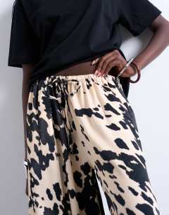 Model wearing Satin wide leg trousers in cow print