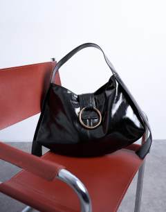 Model wearing Saturn hardware shoulder bag in black