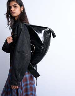 Model wearing Saturn hardware shoulder bag in black