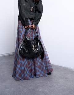 Model wearing Saturn hardware shoulder bag in black