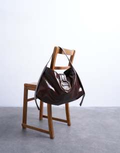 Model wearing Saturn hardware shoulder bag in chocolate